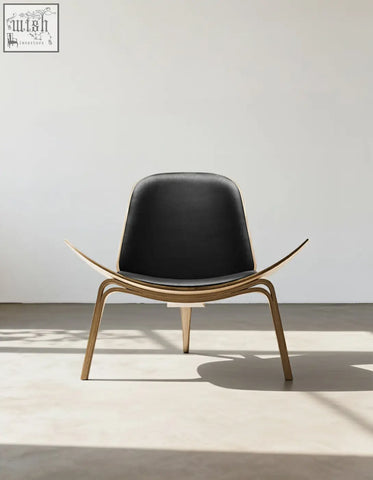 Black leather seat with curved walnut frame and legs on hans wegner ch07 shell chair in black and walnut