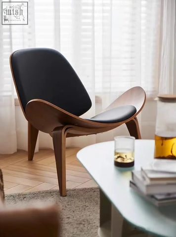 Black leather upholstered ch07 shell chair with sleek curved walnut wooden frame by hans wegner