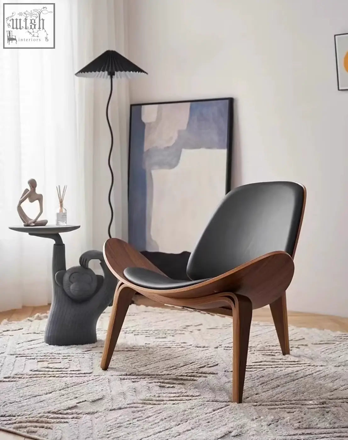 Modern ch07 shell chair with black leather seat and backrest and curved walnut wooden legs in mid-century style lounge design