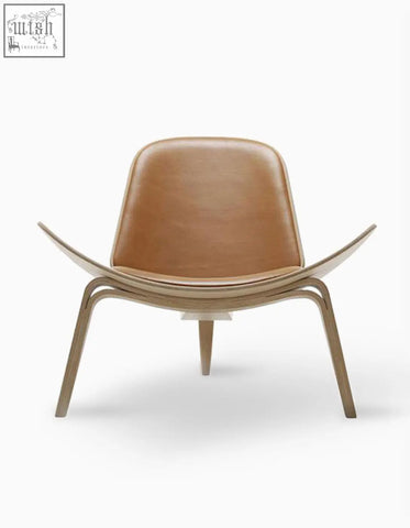 Tan leather upholstered hans wegner ch07 shell chair with sleek curved oak wooden frame in brown and oak finish