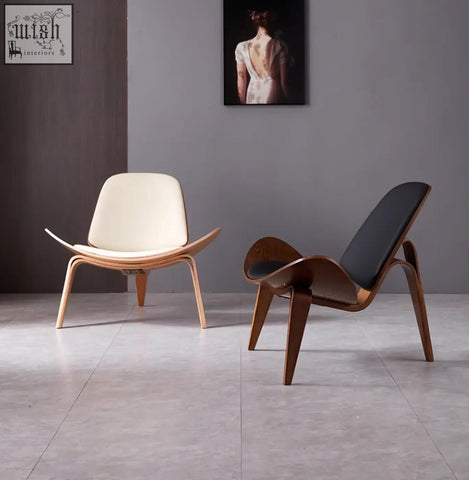 Cream and black upholstered hans wegner ch07 shell chair with curved oak frame in eames-style lounge design