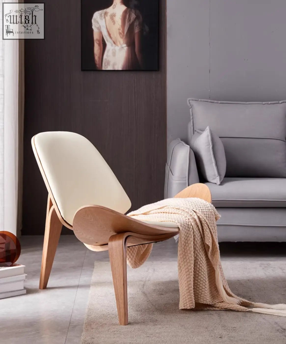 Cream-colored leather hans wegner ch07 shell lounge chair with sleek curved oak frame and minimalist design