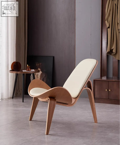 Modern hans wegner ch07 shell chair with cream cushions and oak frame showcasing sleek curved lounge design