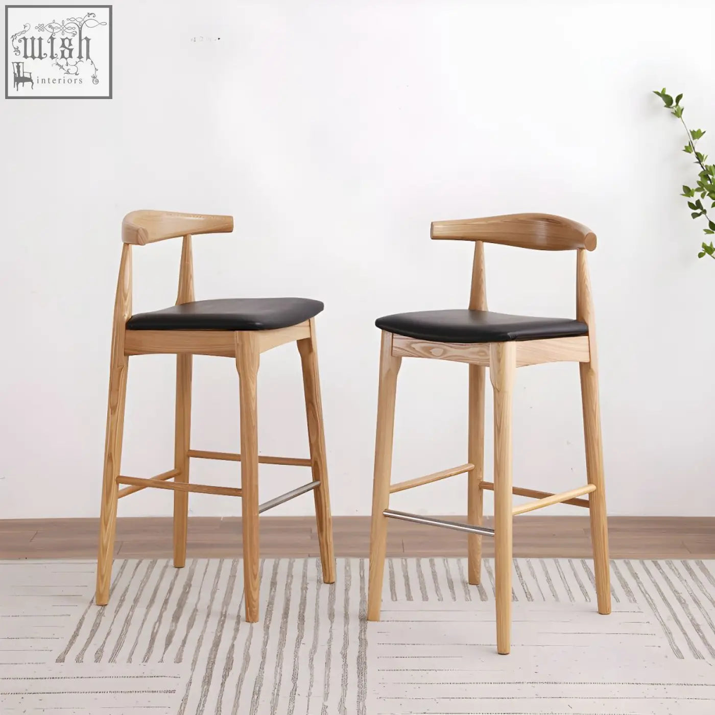 Two hans wegner ch32 bar stools in light oak with black leather seats and curved backrests for stylish seating