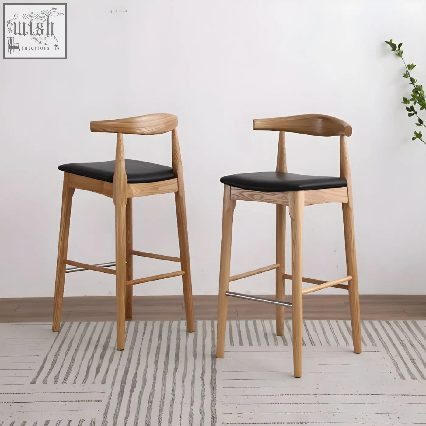 Two minimalist hans wegner ch32 bar stools with oak frames black leather seats and curved backrests