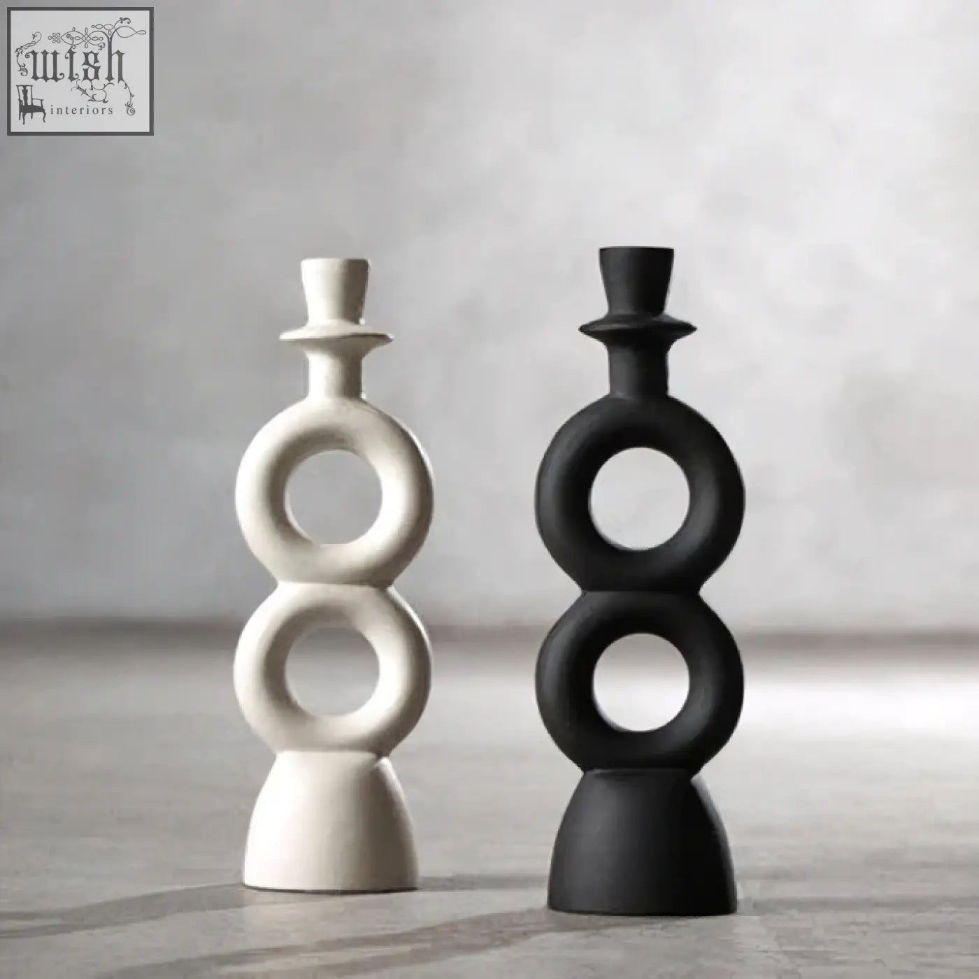Two minimalist abstract candle holders with stacked interlocking rings in matte white and large black glossy finish