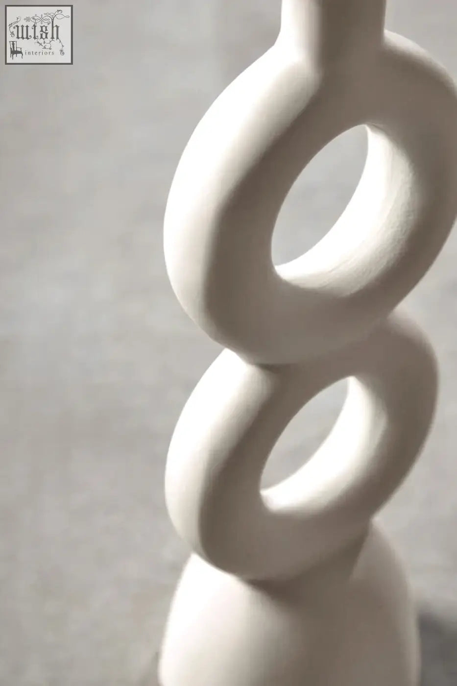Minimalist white ceramic candle holder with smooth interlocking rings perfect for large cream candle display
