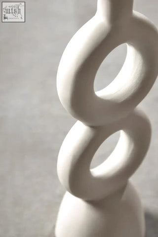 Minimalist white ceramic candle holder with smooth interlocking rings perfect for large cream candle display
