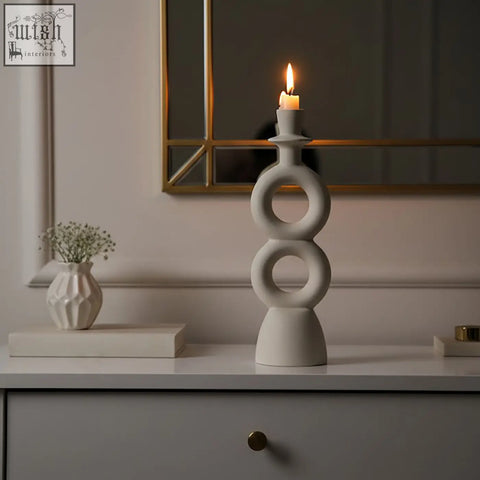 White ceramic candle holder with stacked rings holding a lit large cream candle for elegant decor