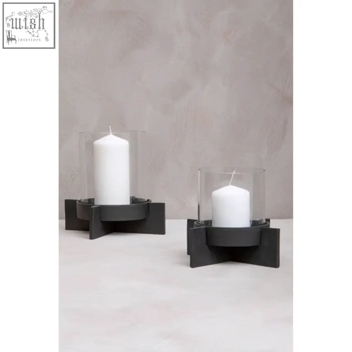 Hapax large matt black finish candle holder with black finish candle holders and clear glass sleeves cradling white candles