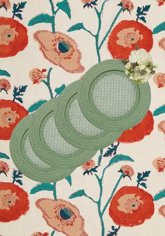 Set of four harbour island round rattan chargers in sage green with woven texture and delicate floral accents