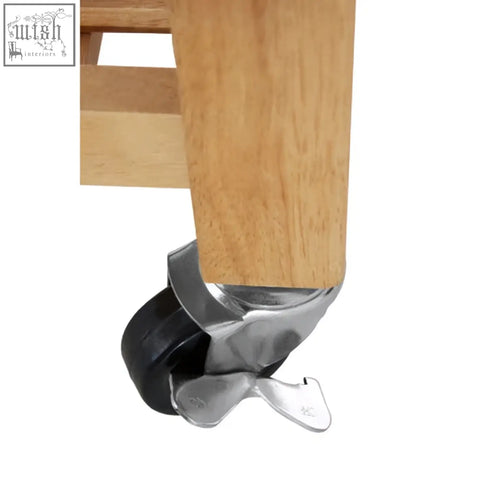 Silver and black caster wheel attached to hevea wood leg of harlow glenn kitchen trolley with two drawers