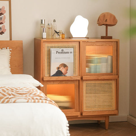 Solid wood harriet sideboard with light wood frame cane panels glass doors and warm interior lighting