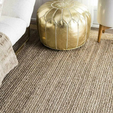 Gold-colored moroccan-style pouf with stitched geometric patterns and starburst design featured in harue rug collection