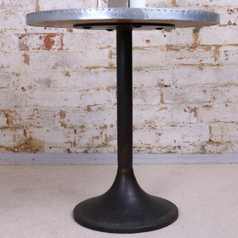 Hatra industrial style round side table with silver riveted metal top and dark matte cast iron pedestal base