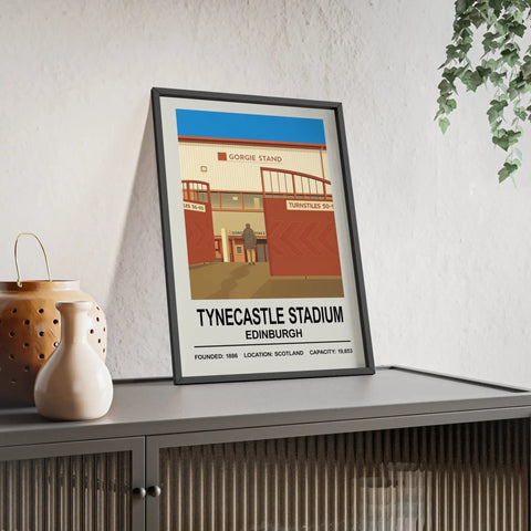 A framed hearts tynecastle stadium print showing a stylized illustration with bold red beige tones and a blue sky in edinburgh