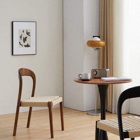 Minimalist henry dining chair with a curved dark wood frame and woven beige rattan seat perfect for dining spaces