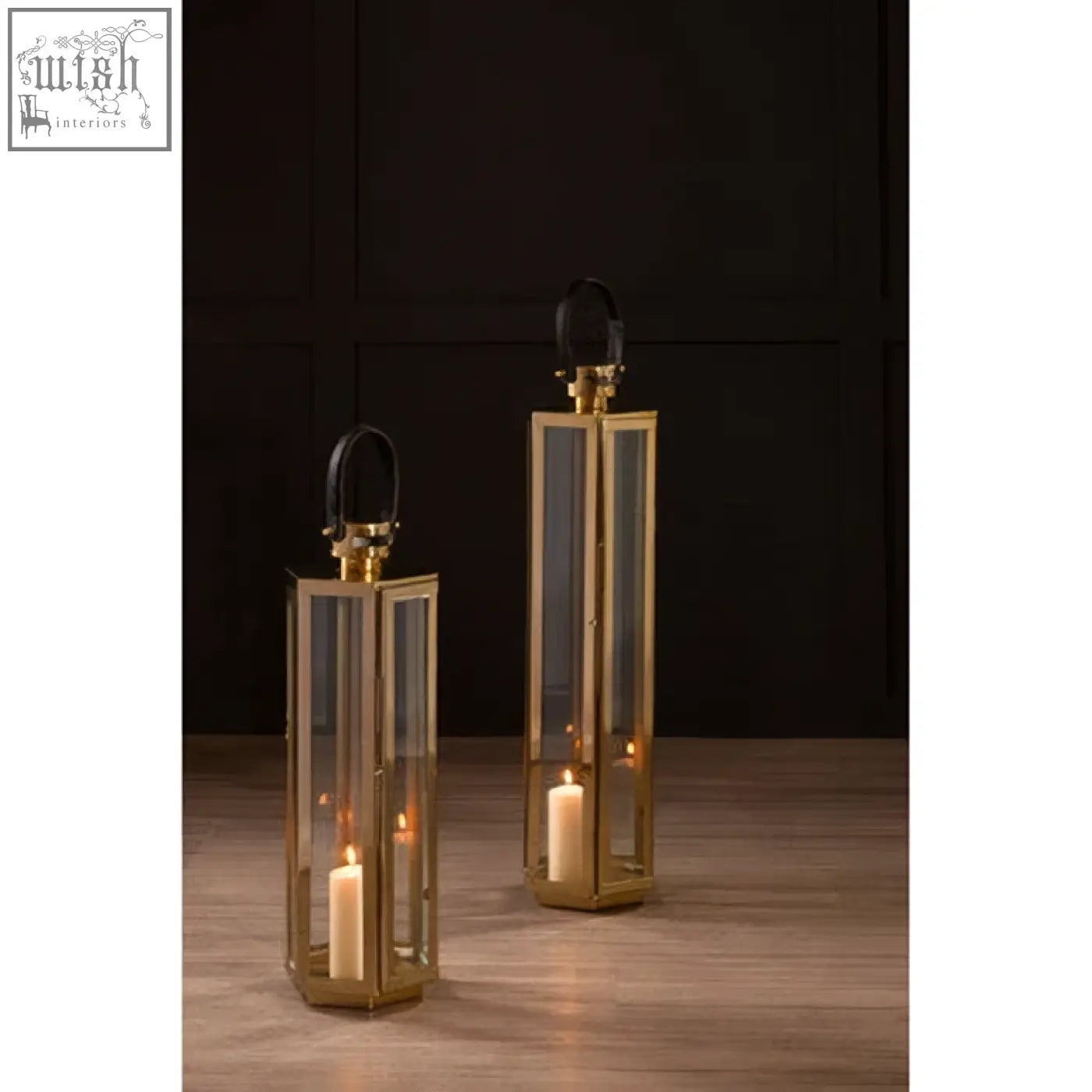 Herber large gold finish lanterns with clear glass panels, lit candles inside, and black leather handles