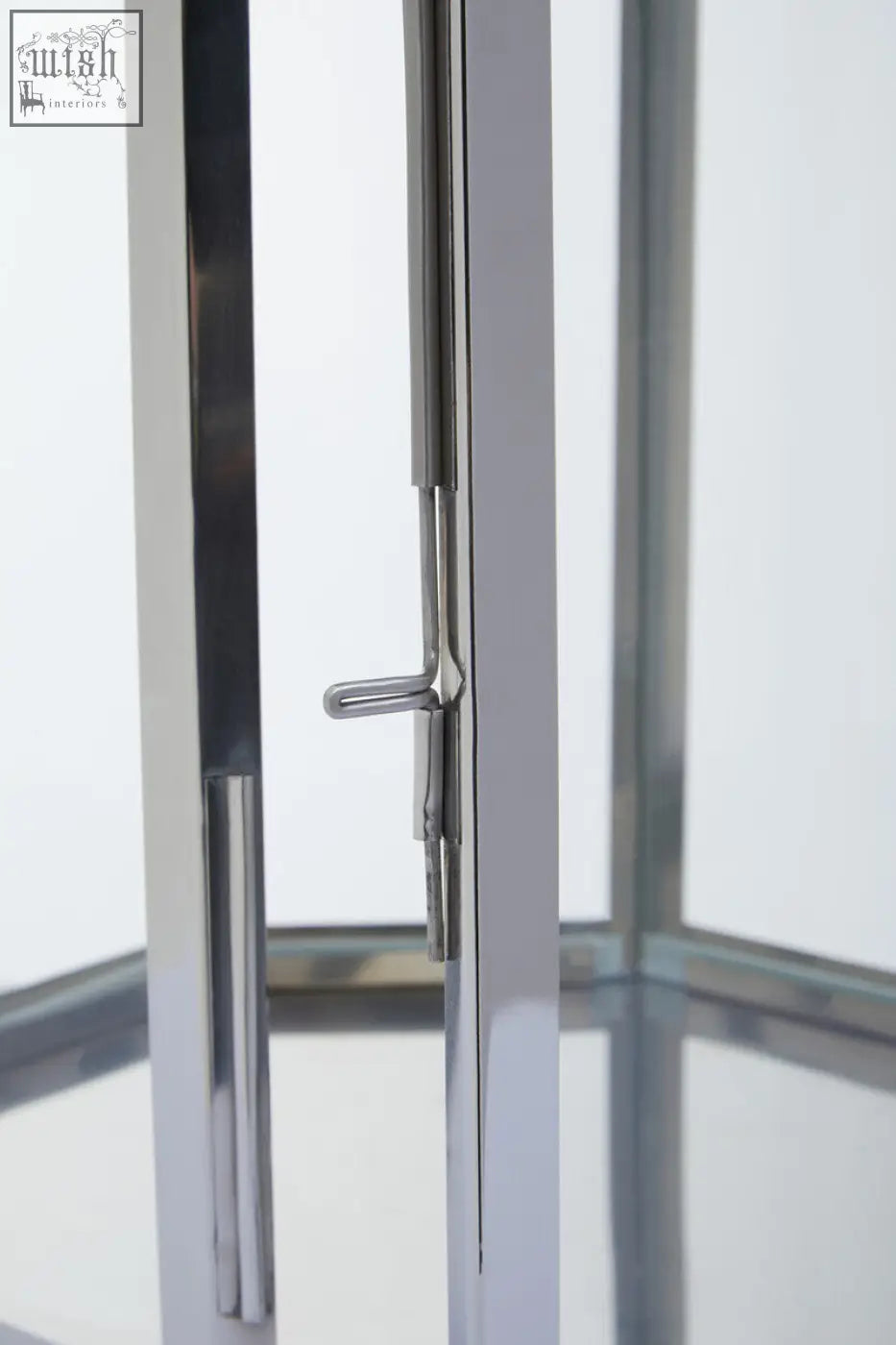 A sleek modern door handle with polished chrome finish and minimalist design on herber large silver steel lantern
