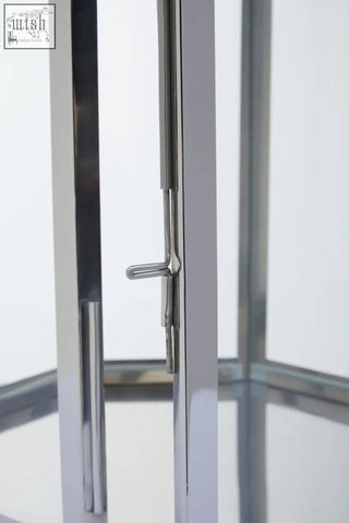 A sleek modern door handle with polished chrome finish and minimalist design on herber large silver steel lantern