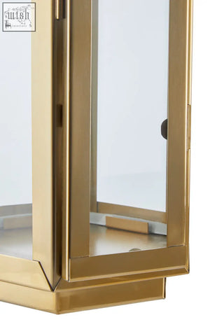 Herber medium gold finish lantern with clear glass panels and a leather handle with hair on leather detail
