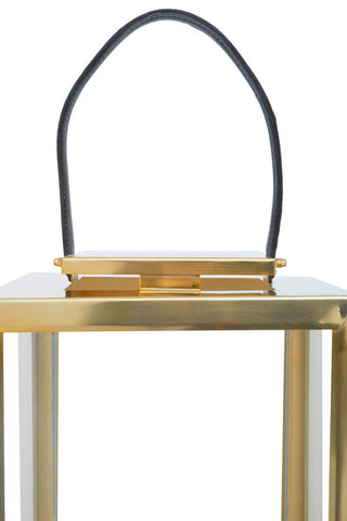 Herber small gold steel lantern with clear glass panels and a black leather handle for easy carrying