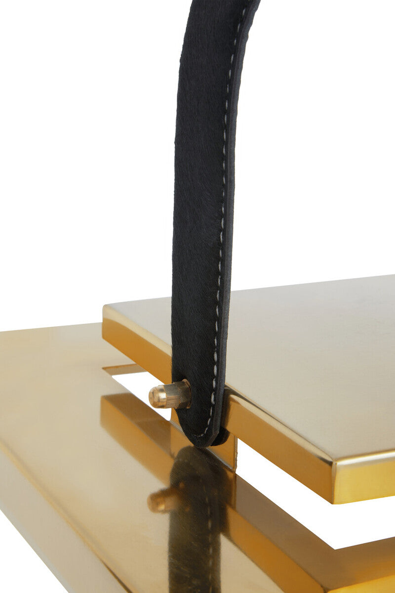 Black leather handle with white stitching attached to a gold-toned frame on herber small gold steel lantern