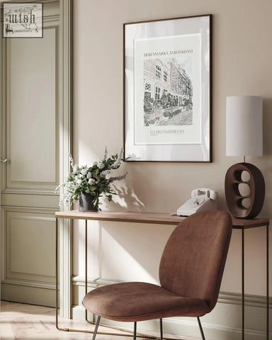 Brown velvet chair with slender metal legs next to herenmarkt amsterdam landscape art print on the wall