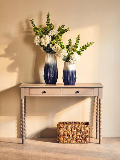 Two navy blue and white ombre ceramic vases with geometric design on heritage two drawer desk with natural wash
