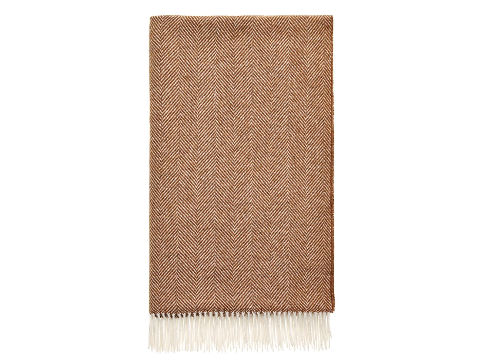 A warm rust herringbone merino lambswool throw with a soft cream fringe perfect for cozying up