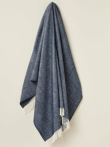 A navy blue herringbone shetland wool throw blanket with cream fringe perfect for cozy home use