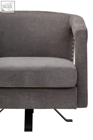 Gray upholstered hestia ash velvet swivel chair with textured fabric and silver nailhead trim on the side
