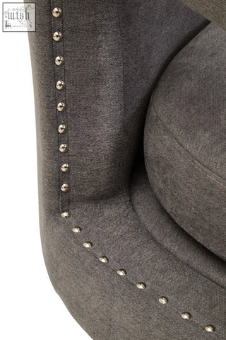 Gray upholstered hestia ash velvet swivel chair with silver nailhead trim along the edges