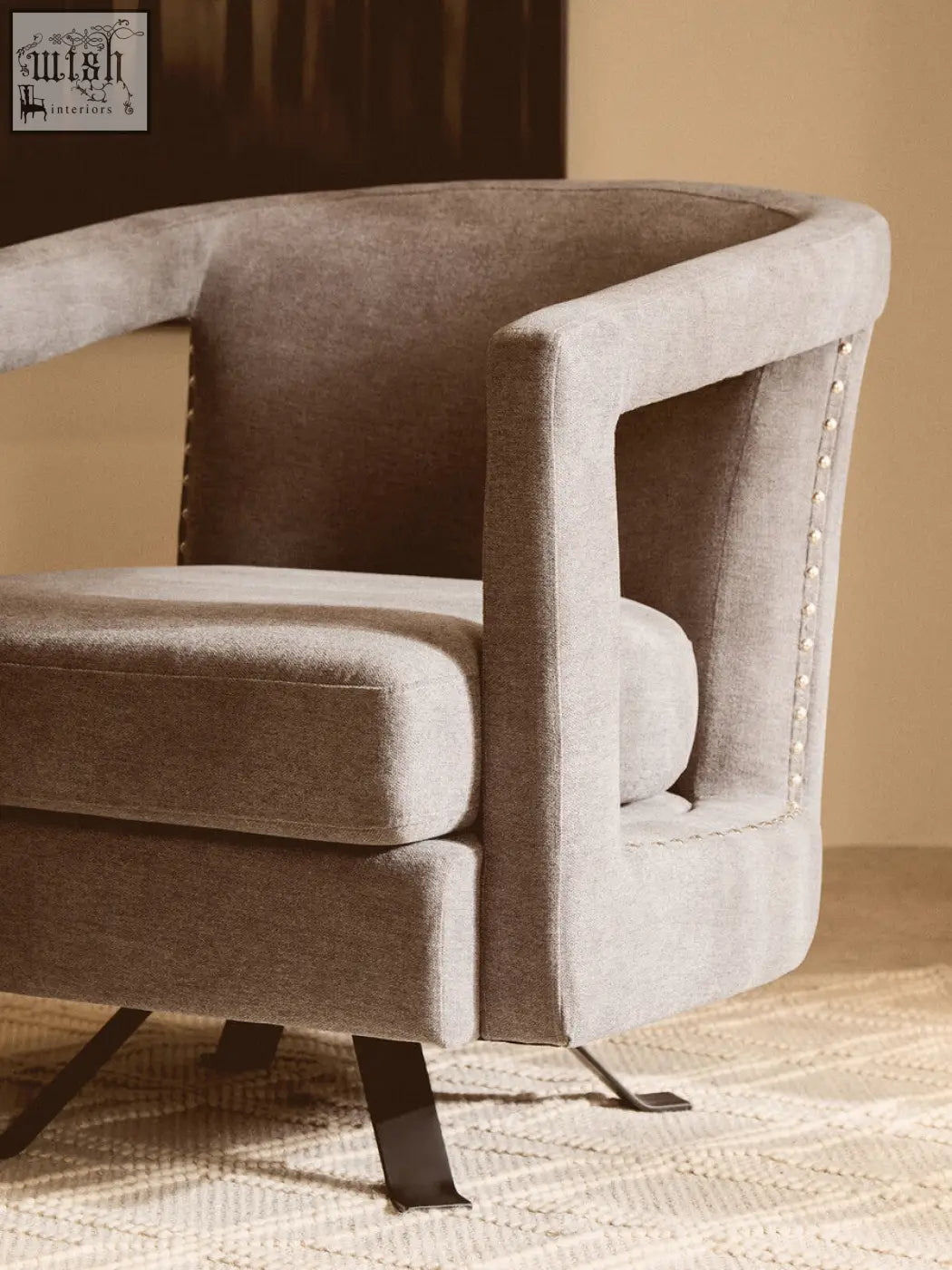 A sleek gray hestia ash velvet swivel chair with tufted back and studded arm details in ash velvet upholstery