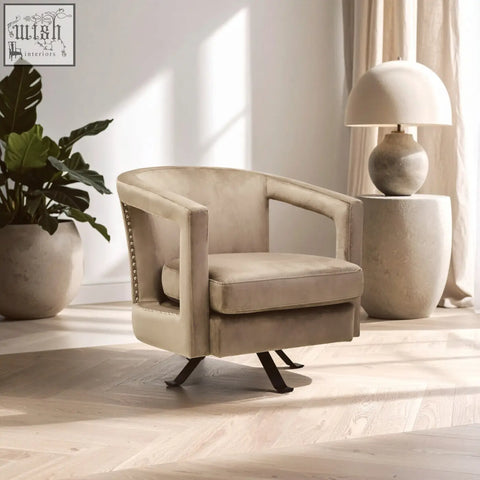 Beige hestia mink velvet swivel chair with studded detailing and black metal base for stylish comfort