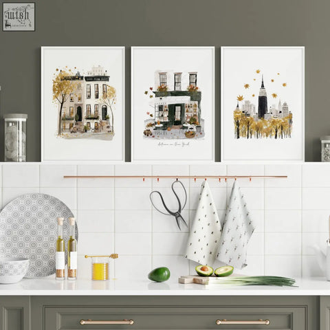 Three framed watercolor travel wall art prints of new york city scenes in autumnal ochre tones with golden leaves