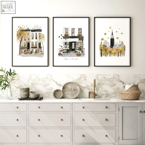 Three framed watercolor travel wall art prints of new york autumn scenes in ochre tones with gold accents and black frames