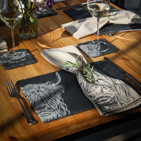 Black slate place mats with white engraved highland cow design perfect for stylish slate place settings