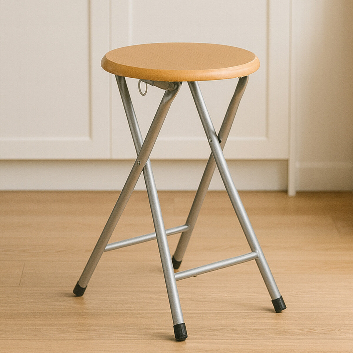 Hinata folding stool with wood veneer seat featuring a light wood-toned round top and silver metal legs with black caps
