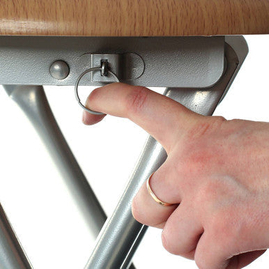 A hand with a gold ring is inserting a key into the silver lock of the hinata folding stool with wood veneer seat
