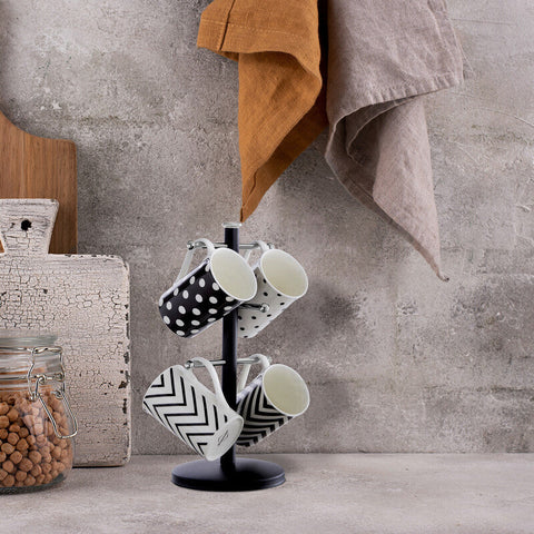 Hirano matt black metal mug tree holding four ceramic mugs with black and white polka dot and chevron patterns