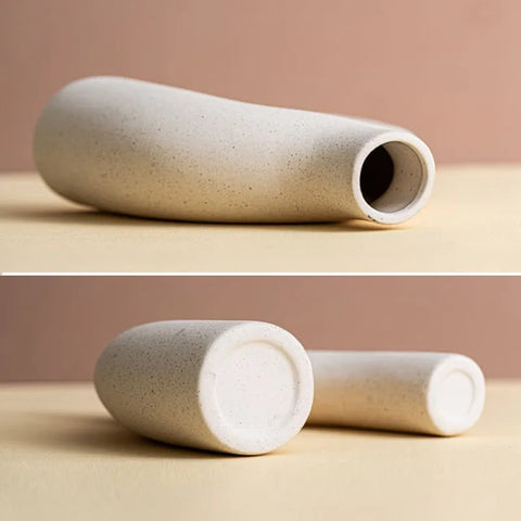 A minimalist off-white ceramic hiroki vase with speckled texture and tapered curved form perfect for decor