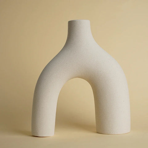 A minimalist white ceramic hiroki vase with a smooth matte finish and an arched asymmetrical design