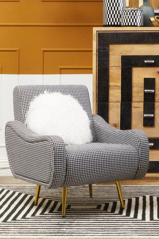 A holli black and white checked armchair with classic houndstooth fabric and sleek gold finish legs