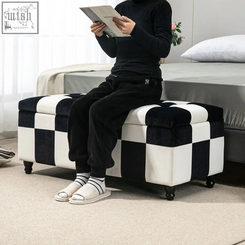 Black and white colour block velvet storage ottoman with button tufted top and dark wooden legs for living room