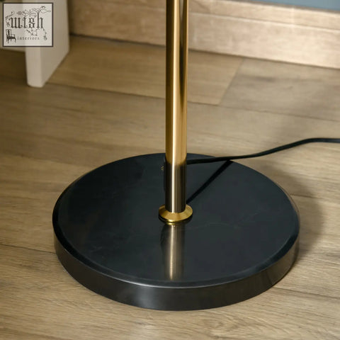A sleek black marble base floor lamp with a polished gold-toned metal pole and convenient foot switch by homcom
