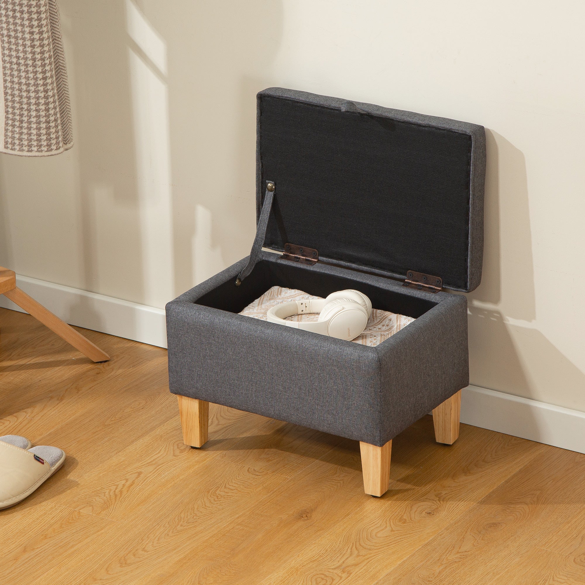 Charcoal grey linen storage ottoman with padded seat wooden legs and black interior perfect for bed end storage