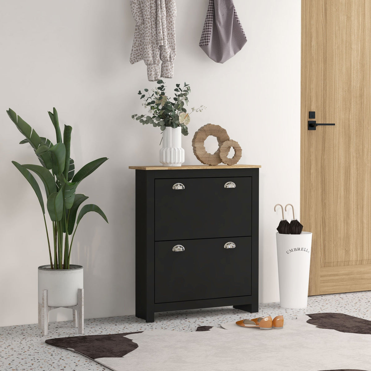 Black two drawer shoe cabinet with light wood top silver handles featuring adjustable shelf and two tipping drawers for storage