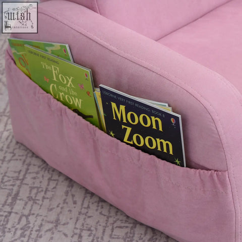 Pink kids armchair sofa bed with wood frame and built-in book pocket holding two usborne first reading books