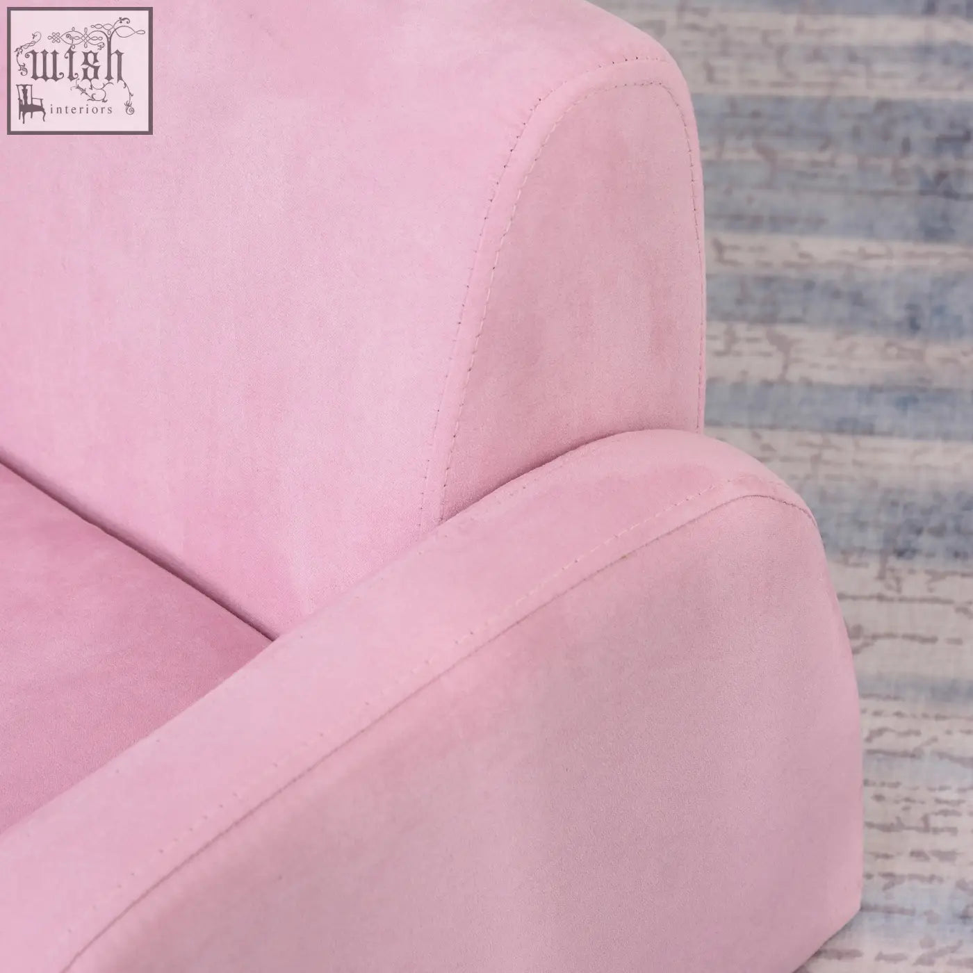 Soft pink suede kids armchair with wood frame and subtle stitching doubles as a sofa bed for playroom or bedroom
